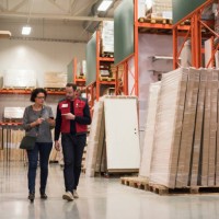 salesman and female customer using smart phone while walking in hardware store - home decoration stock pictures, royalty-free photos & images