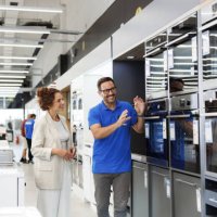 salesperson presenting oven to a customer in an appliance store - home decoration stock pictures, royalty-free photos & images