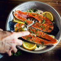 salmon slices seasoned with lemon, sesame oil and parsley - food stock pictures, royalty-free photos & images