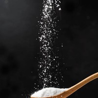 salt in wooden spoon on black background. - food stock pictures, royalty-free photos & images