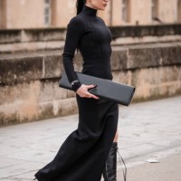 Sandra Corinna Kinzl wears black long turtleneck dress, black Balenciaga sunglasses, black Balenciaga bag, black boots, outside Balenciaga, during...
