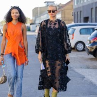 Sara Flaaen Licius wearing orange top, denim jeans & Andrea Steen wearing black sheer dress seen outside Henrik Vibskov during Copenhagen Fashion...