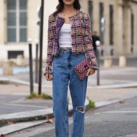 Sarah Ellen wears a colored checkered tweed jacket, a white tank top, blue ripped jeans, a Chanel clutch, outside Chanel, during the Womenswear...