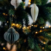 scandinavian christmas paper honeycomb ornament on christmas tree with lights. modern christmas decoration. - home decoration stock pictures, royalty-free photos & images