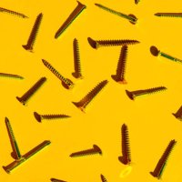 scattered screw nails on yellow orange color background. - nails art stock pictures, royalty-free photos & images