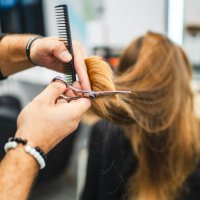 schöne junge frau, die sich die haare schneiden lässt - hairstyle stock-fotos und bilder
