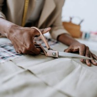 seamstress cutting fabric foreground - fashion stock pictures, royalty-free photos & images