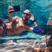 selfie with mobile phone underwater at sea: fish photobombing - travel stock pictures, royalty-free photos & images