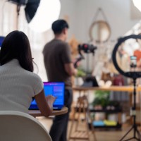 selling live stream online marketing behind back office woman programer checking selling statistic from application screen between stylish influencer woman broadcast selling cloth online sme small business e-commerce - fashio