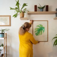 senior caucasian woman decorating her home with a new painting - home decoration stock pictures, royalty-free photos & images