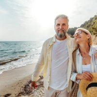 senior couple enjoying day on a beach - travel stockfoto's en -beelden