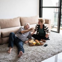 senior couple having a picnic at home - junk food stock pictures, royalty-free photos & images