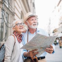 senior couple holding a map and looking at distance - travel stock pictures, royalty-free photos & images