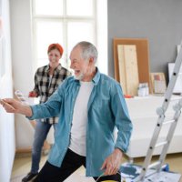 senior couple indoors at home renovating home, painting wall. - home decoration stock pictures, royalty-free photos & images