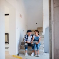senior couple with tablet laying tile floor in new home. - home decoration stock pictures, royalty-free photos & images