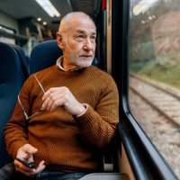 senior man enjoying a view while riding in a train - travel stock pictures, royalty-free photos & images