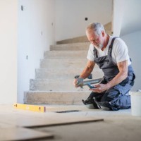 senior man laying tile floor in new home. - home decoration fotografías e imágenes de stock