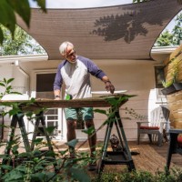 senior man measuring wood plank in back yard - home decoration stock pictures, royalty-free photos & images