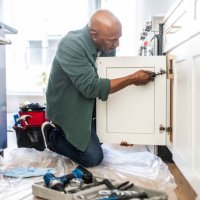 senior man repairing kitchen cabinet at home - home decoration stock pictures, royalty-free photos & images