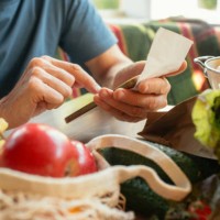 senior man unpacking groceries at kitchen and looking at receipts, financial crisis, environment conservation and sustainability concept - food stock pictures, royalty-free photos & images