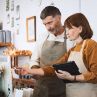 senior white couple work together at own small business retail shop. discuss talk using digital tablet, computer. sell art and craft home decor product. adult business people, sme entrepreneur concept - home decoration stock 