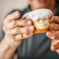senior woman break the rules by eating donut - junk food stock pictures, royalty-free photos & images