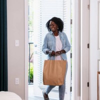 senior woman carrying shopping bag home, thru front door - junk food stock pictures, royalty-free photos & images