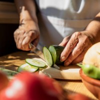 senior woman cutting cucumber in kitchen - food stock pictures, royalty-free photos & images