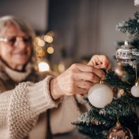 senior woman decorating christmas tree at home - home decoration stock pictures, royalty-free photos & images