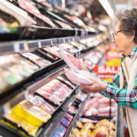 senior woman selecting ground beef in the meat department. - food stock pictures, royalty-free photos & images