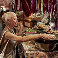 senior woman sitting at fast food stall in market - food stock pictures, royalty-free photos & images