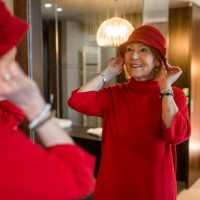 senior woman styling her hat in a mirror - fashion stock pictures, royalty-free photos & images