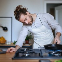 serious man making a healthy meal in the kitchen - food stockfoto's en -beelden