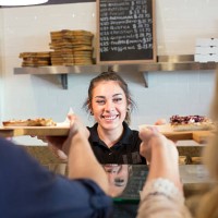 server handing pizza to customers in cafe - junk food stock pictures, royalty-free photos & images