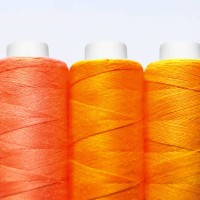 set of spools of red, yellow and orange threads front view close-up macro on white background - fashion stock pictures, royalty-free photos & images