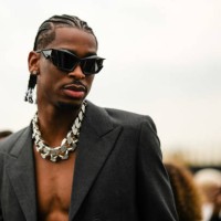 Shai Gilgeous-Alexander wears black sunglasses, a silver and diamonds, a dark gray blazer jacket, outside the Givenchy show, during Paris Fashion...