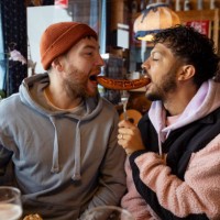 sharing a bratwurst sausage - food stock pictures, royalty-free photos & images