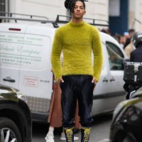 Sharl wears a yellow fluffy turtleneck pullover, leather pants, knee high leather boots with yellow shoelace, outside Marni, during the Womenswear...