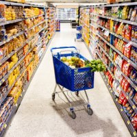 shopping cart in the middle on an aisle at the supermarket - junk food stock pictures, royalty-free photos & images