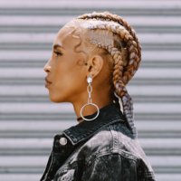 shot of a trendy young woman posing against a roll up garage door - hairstyle stock pictures, royalty-free photos & images