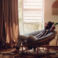 shot of a young man relaxing on a chair at home - home decoration stock pictures, royalty-free photos & images
