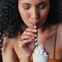 shot of a young woman enjoying a delicious milkshake at a diner - junk food stock pictures, royalty-free photos & images