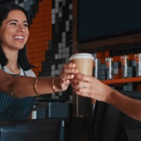 shot of a young woman serving a customer a cup of coffee at a cafe - junk food stock pictures, royalty-free photos & images