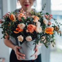 shot of an unrecognisable woman covering her face with flowers in living room - home decoration stockfoto's en -beelden