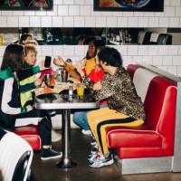 side view of male and female friends talking at table in cafe - junk food stock pictures, royalty-free photos & images