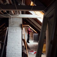 side view of man working in attic under construction - home decoration stock pictures, royalty-free photos & images