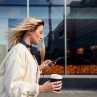 side view of woman using mobile phone while holding disposable cup against building - fashion stock pictures, royalty-free photos & images