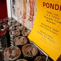 Sign at Pondicheri Indian restaurant telling customers about the Tiffin , reusable take-out containers, Tuesday, June 28 in Houston. Pondicheri is...