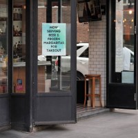 Sign in a restaurant window advertises beer and margaritas for takeout during the coronavirus pandemic on May 19, 2020 in New York City. COVID-19 has...
