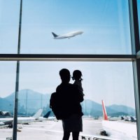 silhouette of joyful young asian father carrying cute little daughter looking at airplane through window at the airport while waiting for departure - travel stock pictures, royalty-free photos & images